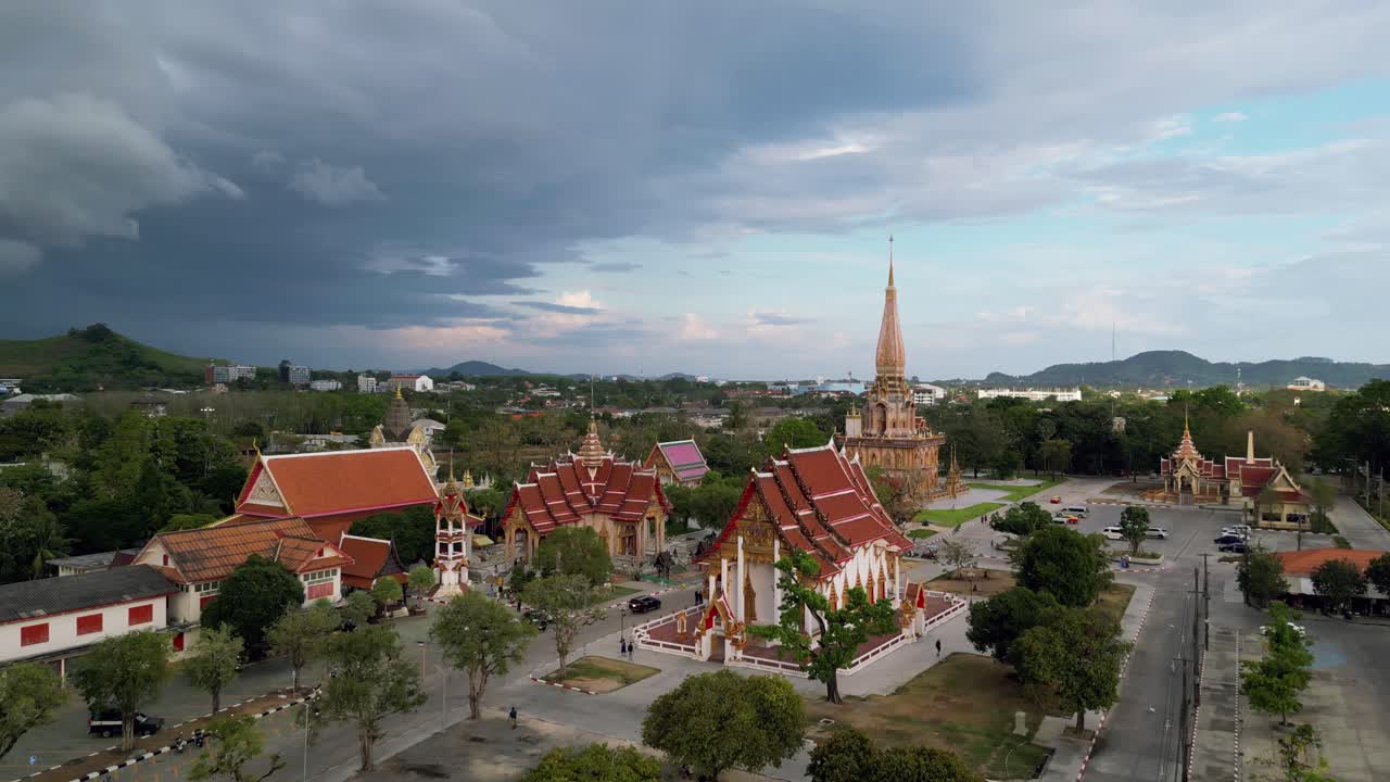 Toàn cảnh trên không của Chùa Wat Chalong, ngôi chùa Phật giáo được tôn kính nhất ở Phuket, được bao quanh bởi cây xanh tươi tốt và bầu trời hùng vĩ