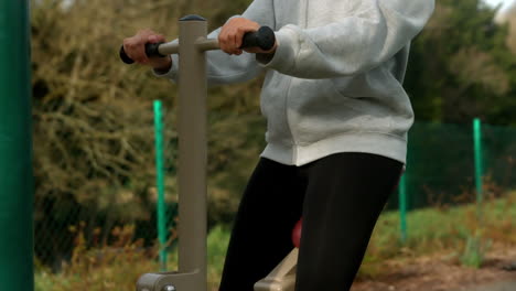 Fit-woman-exercising-on-outdoor-machine