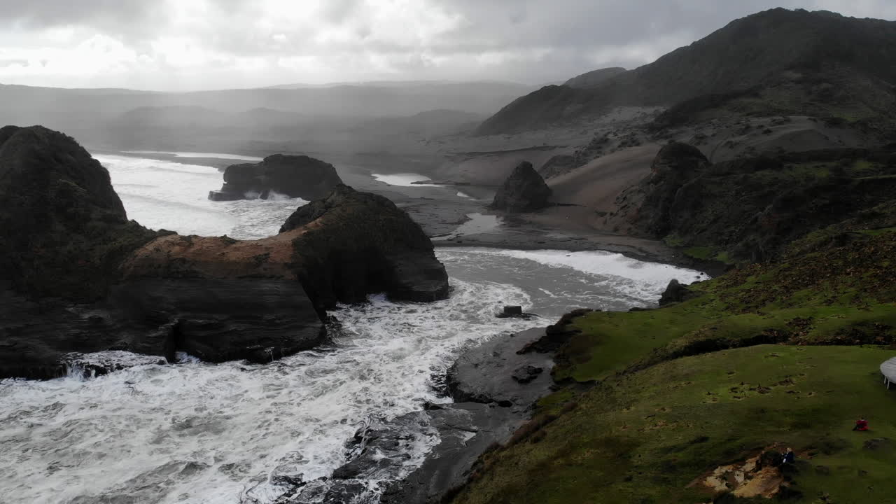 Coastal Landscape with Black Sand Beach, Rocks, and Mountains