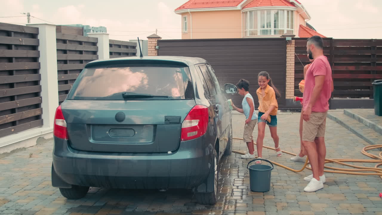 Family Of Four Washing Car Together