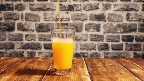 pouring a glass of orange juice slowly with bubbles