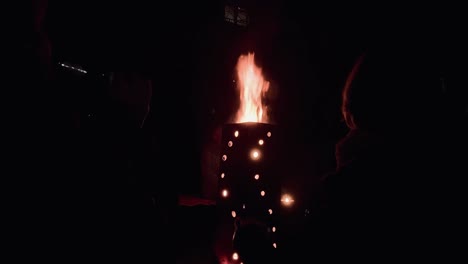 close up shot of bonfire outdoor at lake with people enjoying holiday