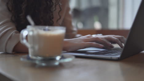 mujer trabajando en una computadora portátil en un café