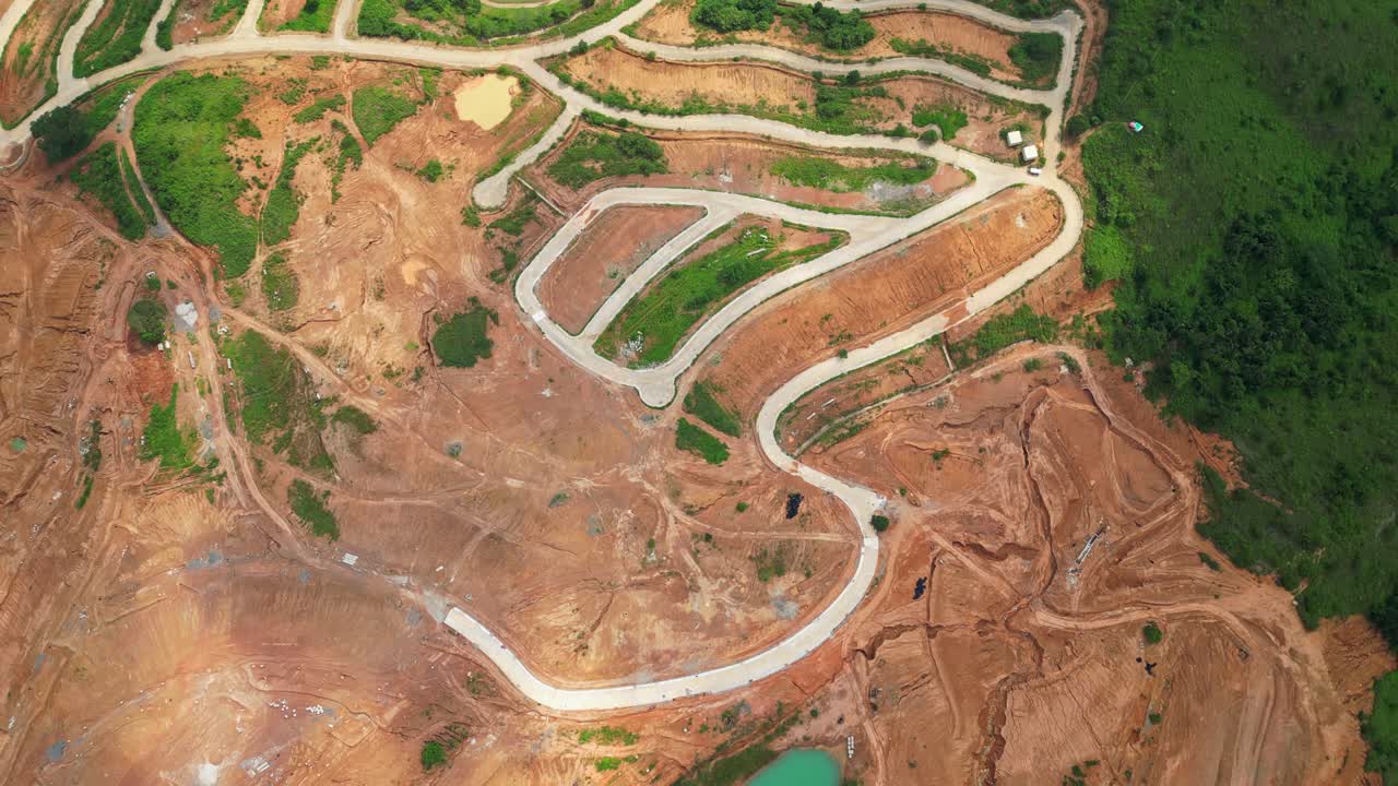 Top‑view aerial of Tandatangan Signature Golf Course in Mariveles, Bataan, showing green fairways with winding paved roads curving through the hilly landscape