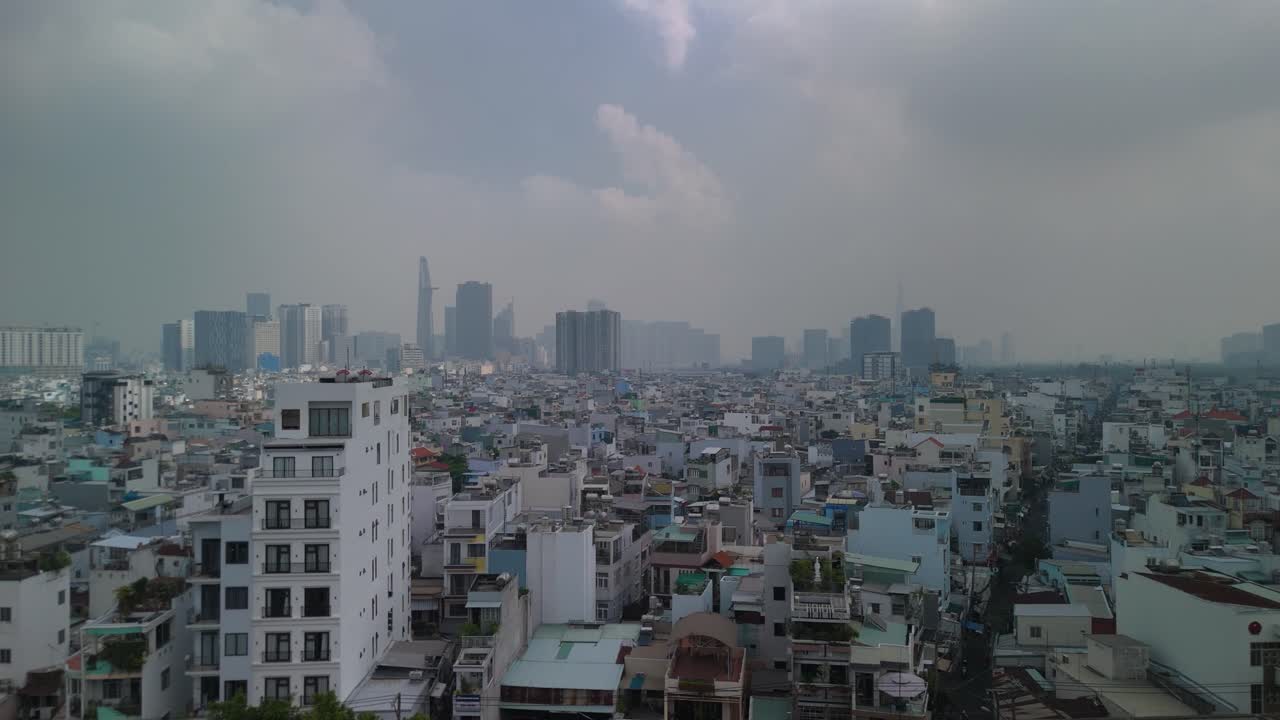Aerial view of Ho Chi Minh City skyline with high density urban area in foreground with dramatic morning sky. Tracking shot from left to right.