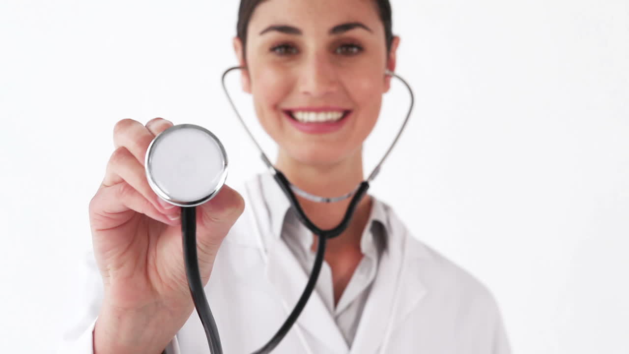 Doctora sonriente mostrando su estetoscopio