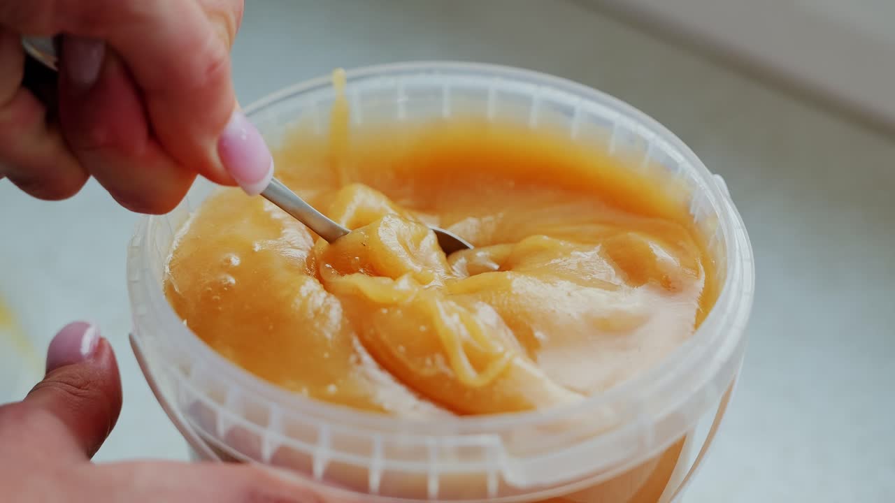 Viscous honey texture and struggle as oversized portion resists tiny teaspoon