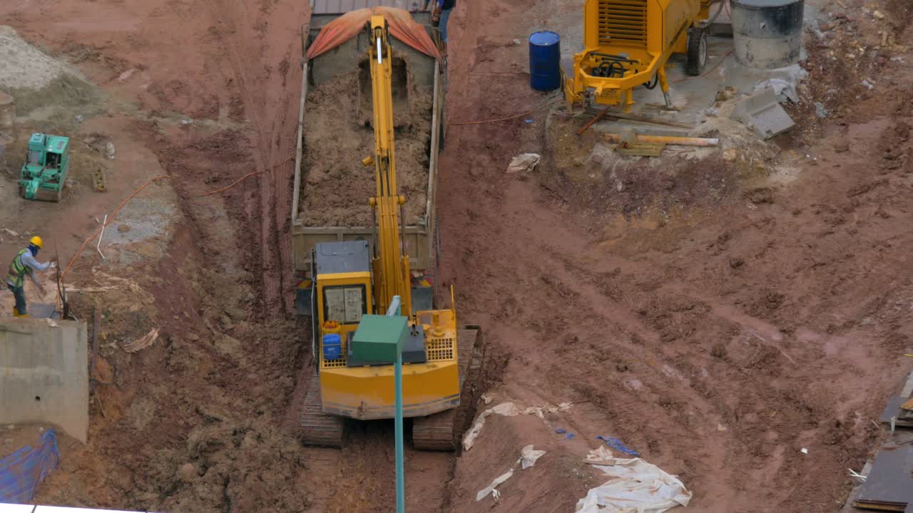 en kuala lumpur malasia en el pozo la excavadora vierte tierra en un camión