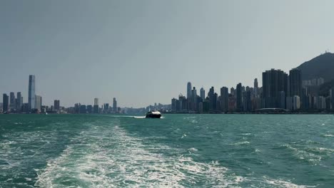 Victoria-Harbor-in-Hong-Kong,-skyscraper-buildings-during-the-day,-view-from-boat