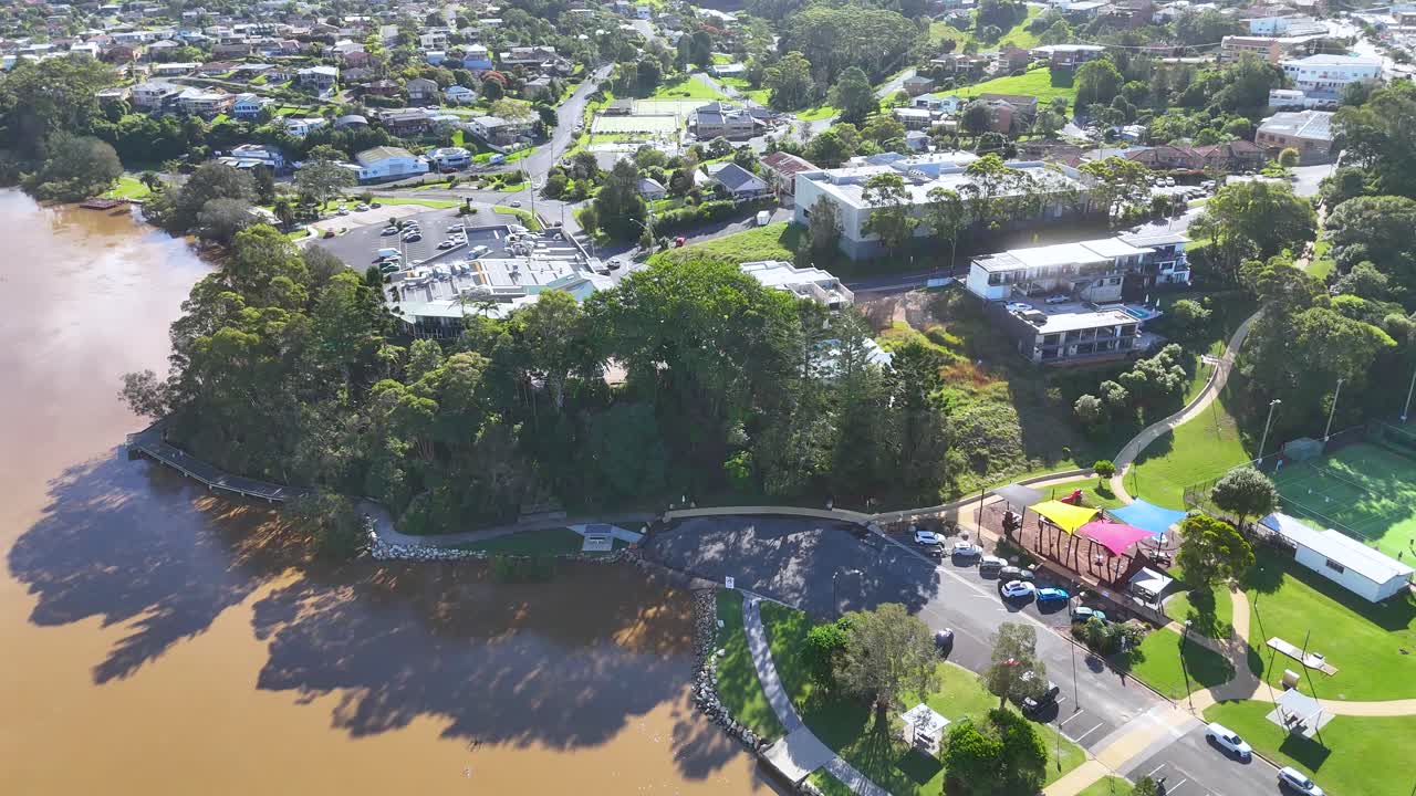 Aerial drone video over riverside neighborhood in Nambucca Heads, Australia, with sunlit greenery