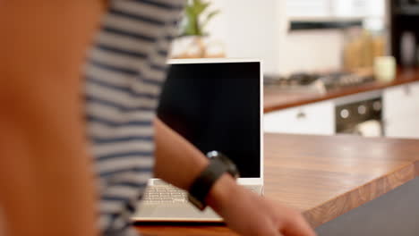 Hombre-Birracial-Trabajando-Desde-Casa-Usando-Una-Computadora-Portátil,-Cámara-Lenta