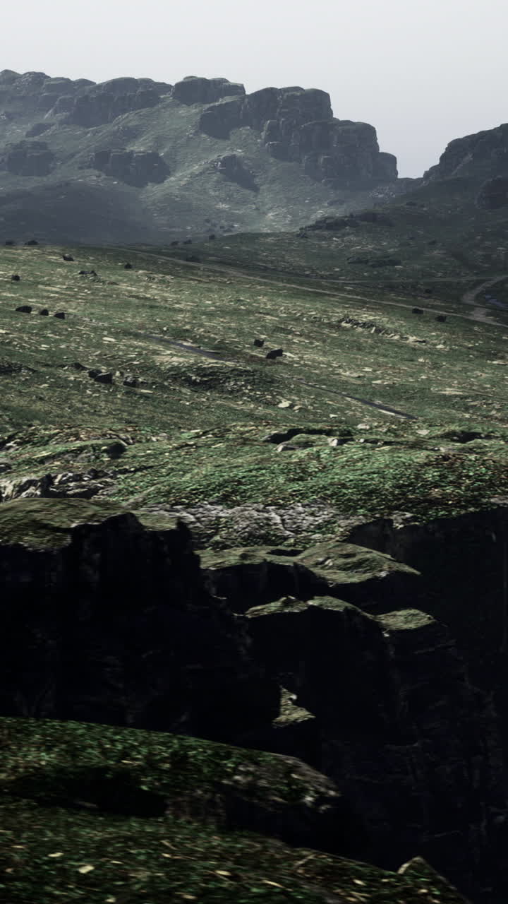 A vast rocky landscape features a winding path leading through green terrain