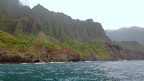 4k hawaii kauai boating on ocean floating left to right with waves crashing along mountain shoreline