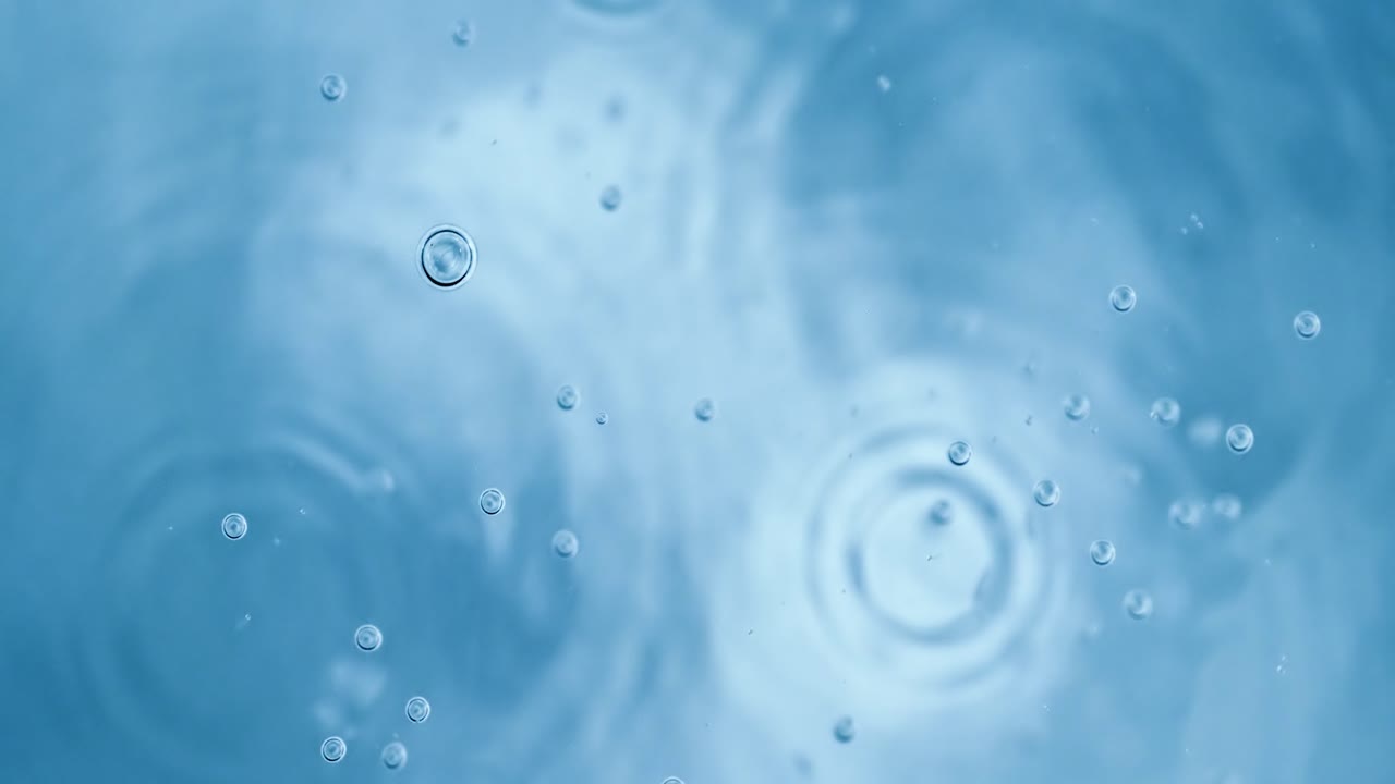 슈퍼 슬로우 모션으로 파란색 추상적인 배경에 물에 산소 거품이 있습니다.