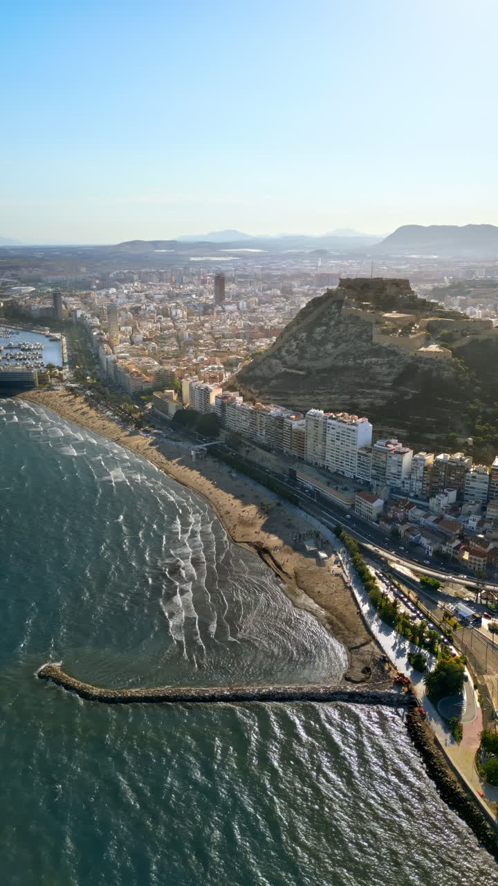 Vista aerea da drone del Castello di Santa Barbara sulla costa di Alicante, Spagna, con la città e il mare sullo sfondo. Verticale