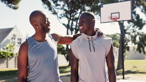two men playing basketball on an outdoor court
