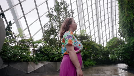 mujer con vestido impreso disfrutando de las vistas del jardín botánico del bosque nublado en singapur