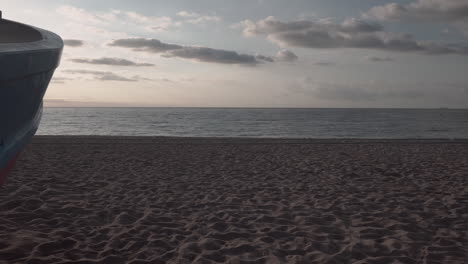 Pan-De-Clip-De-4k-A-La-Derecha-De-Un-Pequeño-Bote-De-Pescador-Clásico-En-La-Arena-De-Una-Playa-Del-Mar-Mediterráneo-Al-Amanecer-Que-Muestra-Un-Estallido-De-Sol