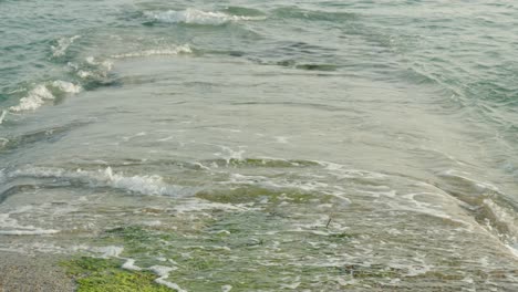 slowmotion close up of waves hitting a pier or dock leading into the ocean sea