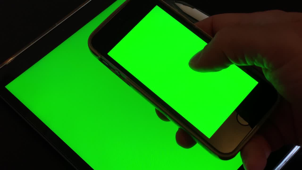 직장에서 휴식을 취하는 동안 녹색 ipad를 확인한 후 녹색 전화에서 일부 이미지 슬라이드를 스크롤하는 건강한 남자