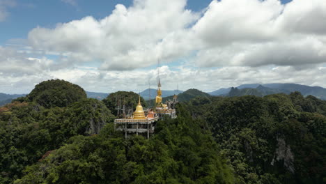 Krabi-Stadt-Wat-Tham-Sua-Tigerhöhlentempel,-Goldene-Buddha-Statue-Auf-Einem-Berggipfel,-Umgeben-Von-Kalksteinfelsen,-Atemberaubende-Krabi-Landschaft,-Drohnenaufnahmen-Aus-Südthailand