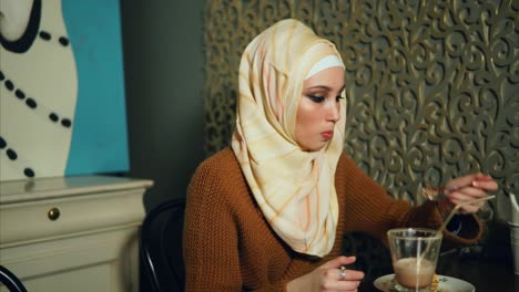 una mujer comiendo postre en un café.