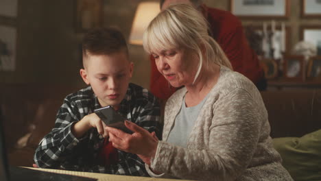 grandparent and grandchild using a smartphone