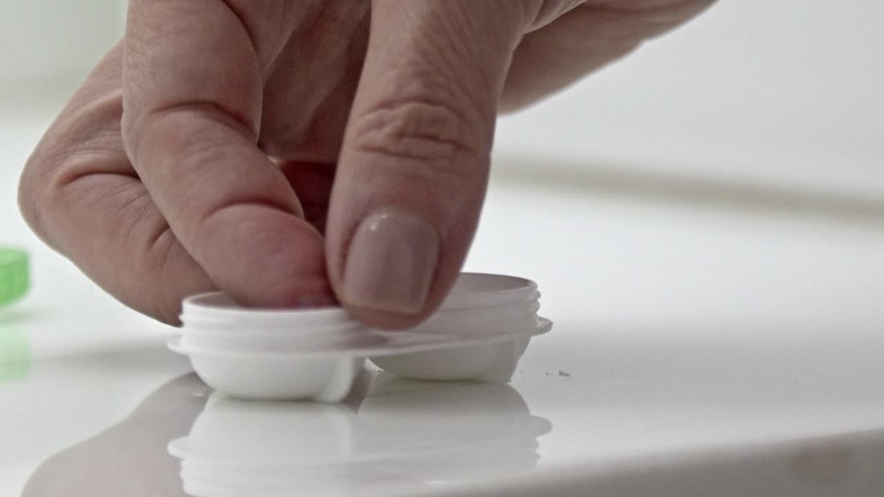 Woman Handling Contact Lenses and Case