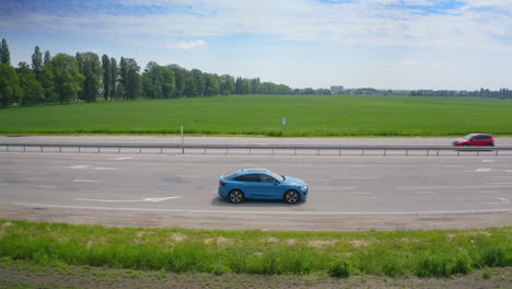Blue luxury car on road on the field background. Very fast driving of audi car on highway under beautiful sky at daylight.