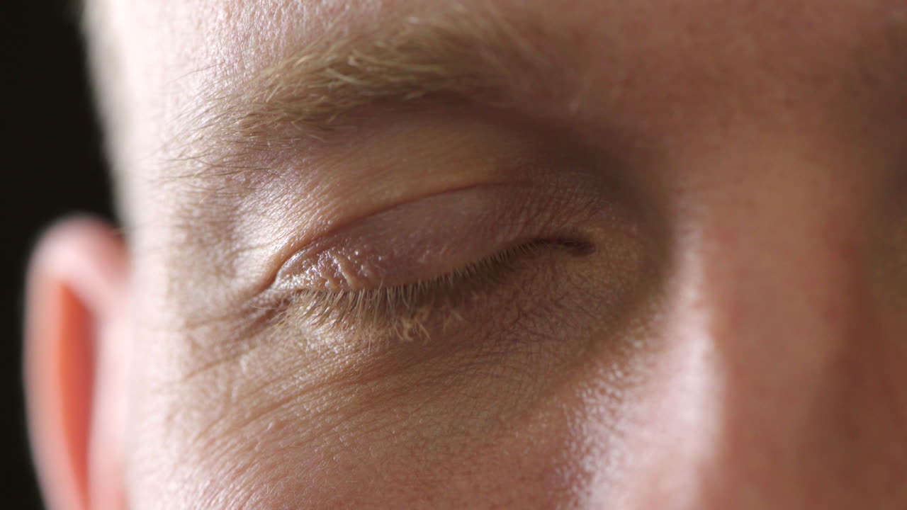 primer plano de un ojo masculino con lentes de contacto parpadeando