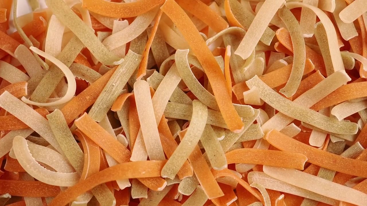 Pasta secca colorata che cade al rallentatore