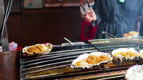 oysters being grilled at a street food stall