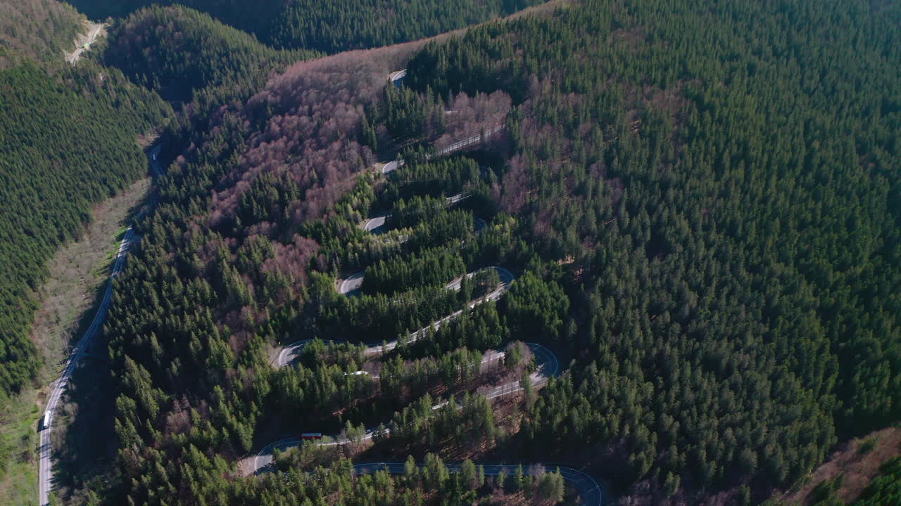 retiro aéreo sobre el tráfico que conduce una carretera sinuosa sobre el paso de bratocea, rumania