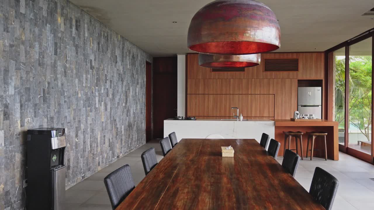 cámara deslizante cinematográfica a través de una villa privada de lujo con paredes de piedra y mesa de comedor de madera