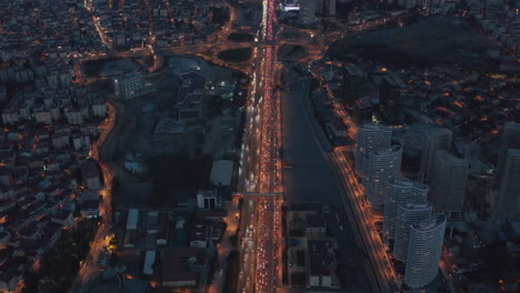 Lange-Autobahn-Oder-Autobahn-Bei-Nacht-Im-Finanzviertel-Von-Istanbul-Endlos-In-Die-Ferne-Mit-Stau-Und-Roten-Lichtern,-Luftbild