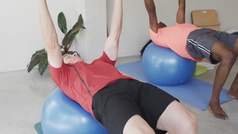 hombres mayores diversos usando pelotas de ejercicio con entrenadora de pilates femenina, sin alteración, en cámara lenta