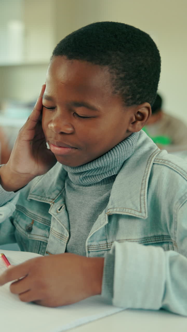Young Boy Concentrating and Thinking Hard in Classroom