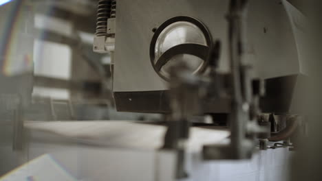 close up of a printing machine separating sheets of paper and sending it forward on the production line