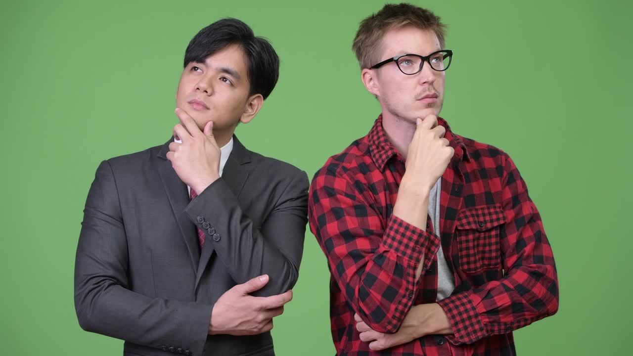 젊은 잘생긴 아시아 사업가와 젊은 스칸디나비아 사업가가 함께 일하고 있습니다.