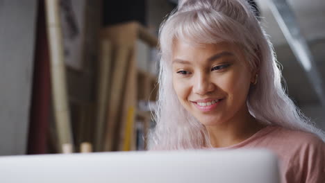 Close-Up-Of-Female-Business-Owner-In-Workshop-For-Sustainable-Bicycles-Doing-Accounts-On-Laptop