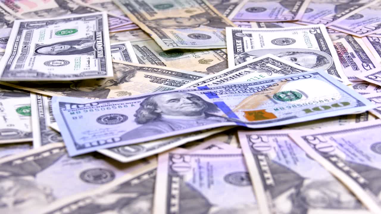 Banconote di dollari americani di diversi tagli cadono sul tavolo.