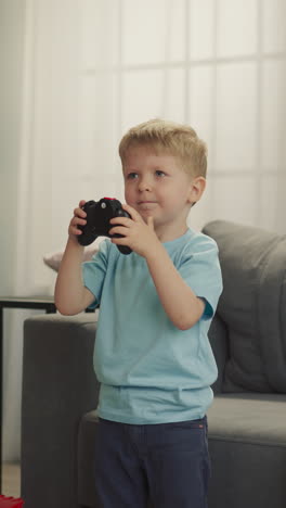 niño pequeño y niña en edad preescolar juegan un videojuego difícil con consolas. los hermanos se sienten tristes por perder sentados en el sofá contra una planta de interior y una lámpara