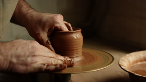 artist sculpting clay product in pottery. man producing new product in workshop