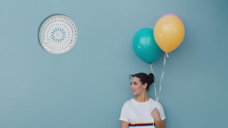 mujer feliz sosteniendo globos coloridos para la celebración de la fiesta de cumpleaños sonriendo juguetón disfrutando de la diversión 4k