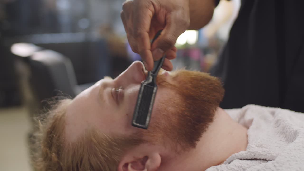 Barber Brushing Beard of Male Client