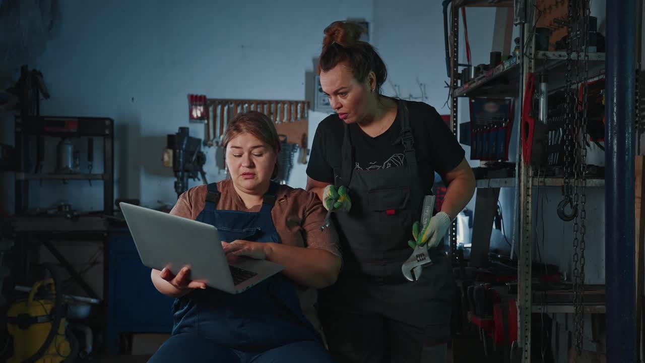 Women Mechanics Collaborating in a Garage
