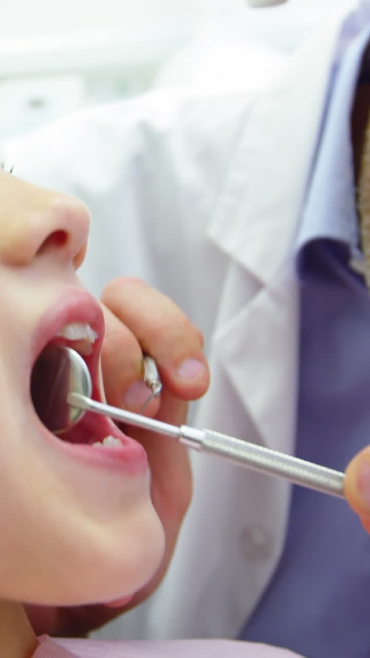 Dentist examining a young patient with dental tools