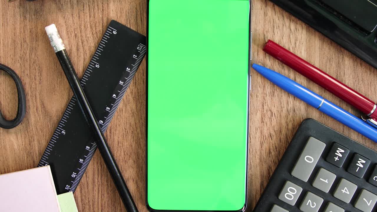 Green screen smartphone on the office table top view