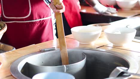 artisan preparing noodles in a bustling kitchen