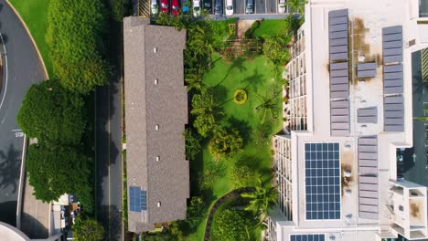 green gardens and buildings with solar panels on the roof, overhead aerial view moving forward.